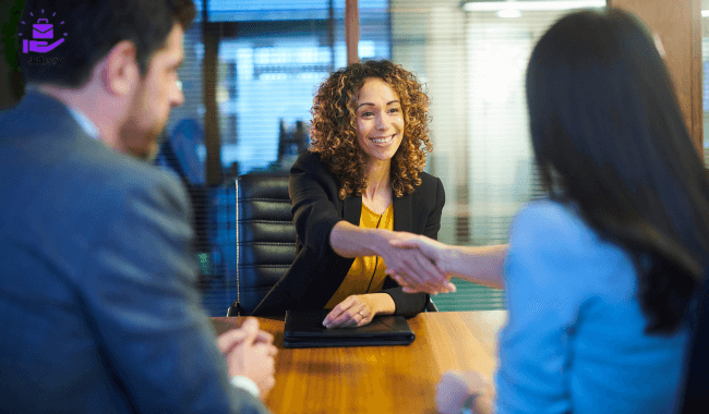  Two women shaking hands at a meeting during a walk-in interview.